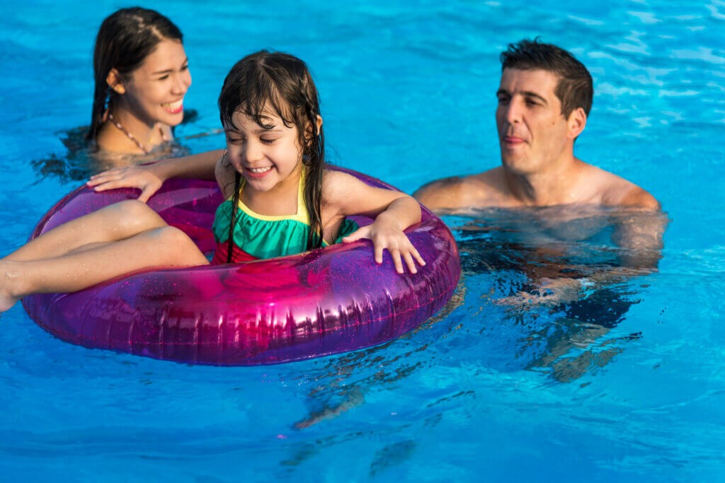 CardFamily: aproveite um ano de visitas ao parque aquático Acquamania! | um casal e uma criança com boia na piscina | Acquamania