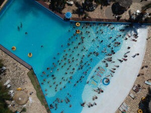 Atrações do Acquamania: Piscina de Ondas com fundo azul, cheia de pessoas curtindo e relaxando.