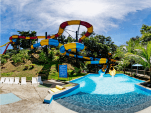 Atrações do Acquamania: Nessa foto mostra uma piscina de fundo azul e dois toboáguas. O Coral de cor amarelo e vermelho, e a Coralina de cor azul e amarelo.